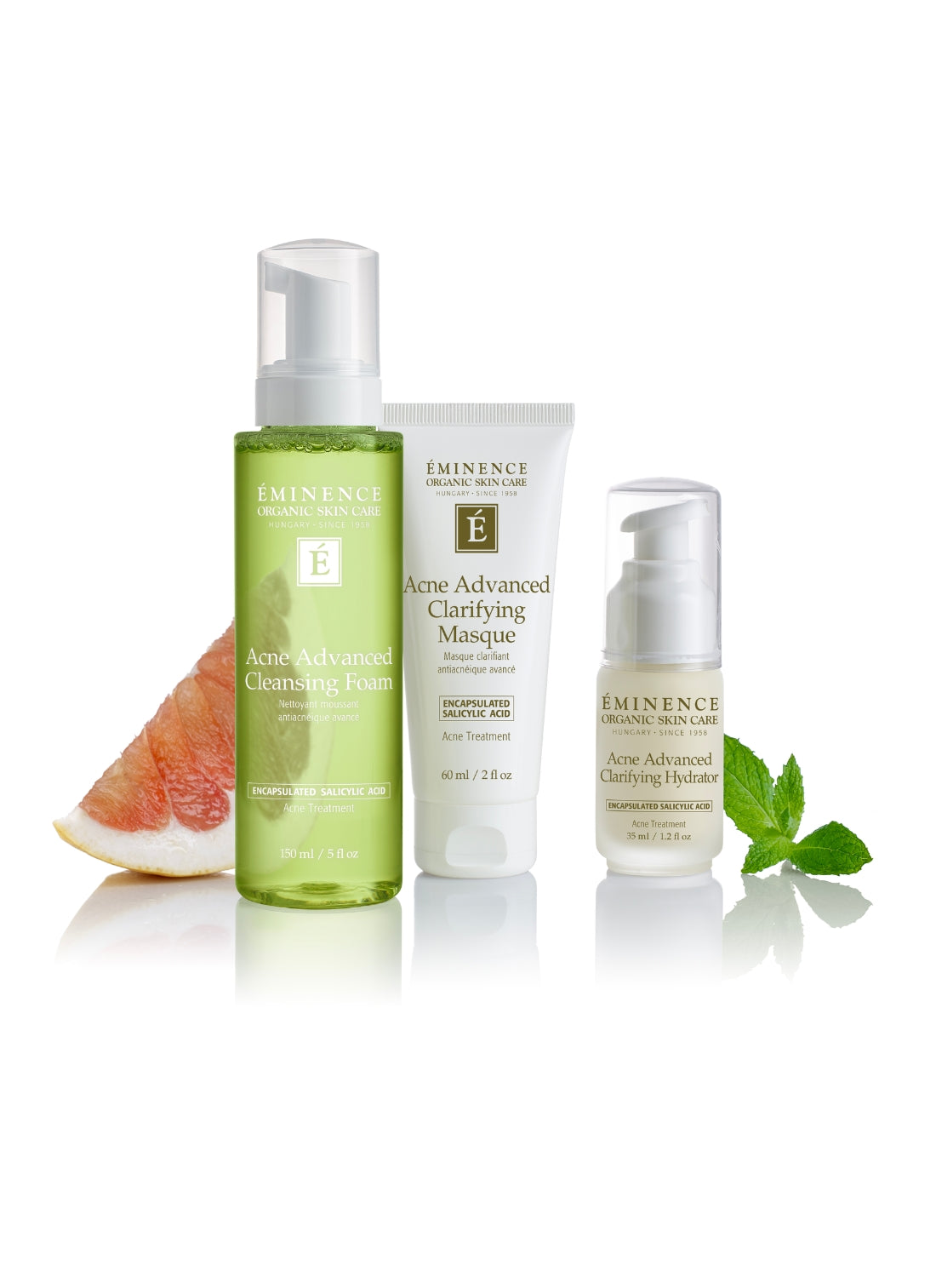 eminence acne acne system products with grapefruit slice and mint leaves